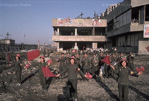 Pyongyang. Una banda militare suona per dei lavoratori edili.jpg