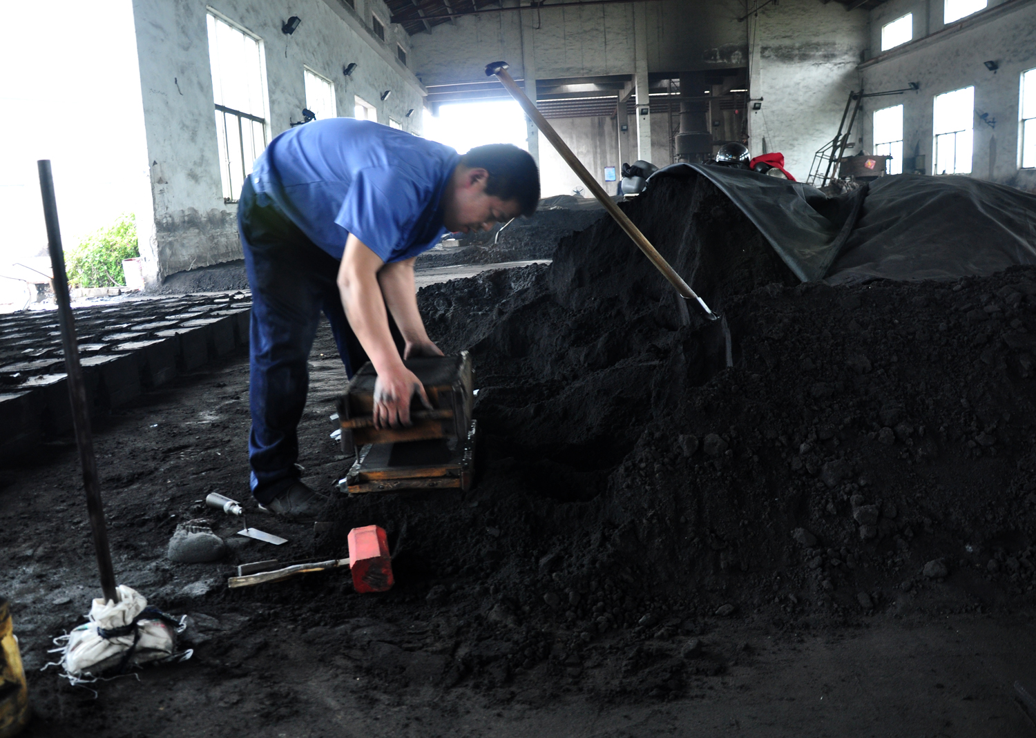 导墅镇佳飞亚机械有限公司工人陈金胡在铸造车间“造型”。（诸葛书清摄于4月12日）