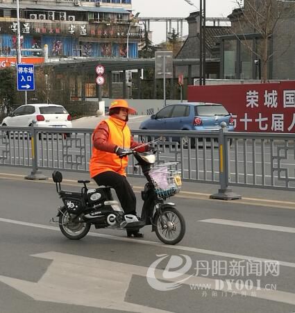 张丹凤穿行在马路中央捡拾垃圾